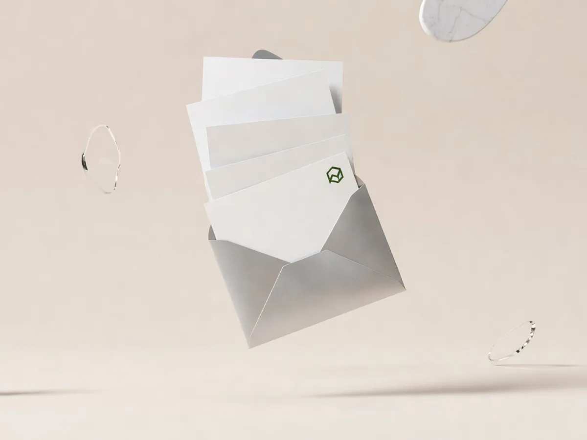 Busta di carta d'argento che si apre in aria lasciando uscire fogli bianchi ordinati in una fila precisa, con un timbro verde muschio su uno di essi: automatizzare le email in azienda