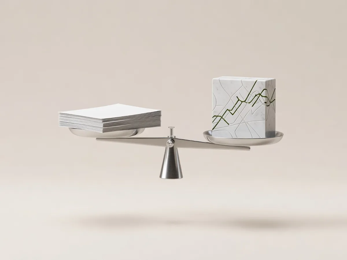 Bilancia d'argento in equilibrio tra un foglio di carta bianco e un blocco di marmo con segni verde muschio: i preventivi automatici che pesano dati e listino prima di uscire